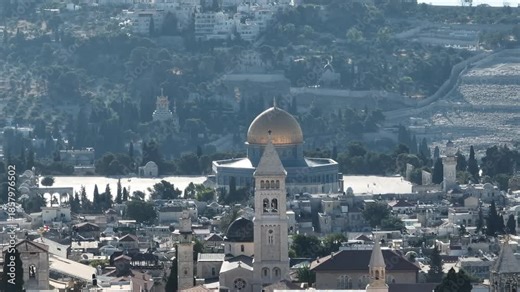 Aerial view over Jerusalem Old City Drone footage showing church towers in the foreground and the Dome of Rock with Mount of Olives behind, Jerusalem, Israel, November 2025