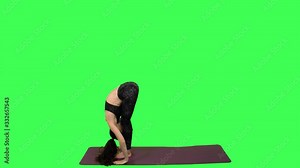 Flexible yoga Instructor practices a set of complex standing positions, over green screen. Long shot.