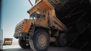 Industrial sand mining - Big loader working at sand area. Dolly Right - Dumping sand into a mill, Industrial machinery at sand quarry, 4K footage