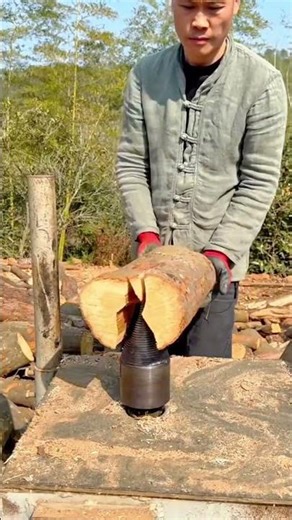 Splitting a wooden log using a mechanical screw splitter mounted on a workbench outdoors steadily