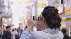 Beautiful youthful women taking photos of Namba food Street Osaka