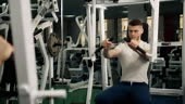 The man at the gym doing exercises for the chest on a dedicated...