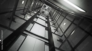 Inside the dark elevator shaft. Vertical construction witch machinery and ropes.