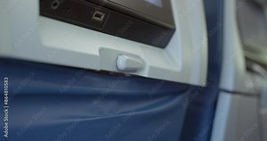 Opening and closing plane tray table. passenger's hand opening the tray table on an airplane. air travel experiences. Having a meal on a flight. Dinner lunch or breakfast.