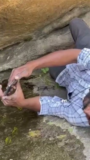 கிருஷ்ணகிரி அருகே சங்க கால தமிழ் மக்களின் கலாச்சாரத்தை பதிவு செய்துள்ள பாறை ஓவியத்தை படம் பிடிக்கும்