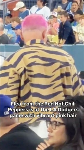 Flea from Red Hot Chili Peppers at LA Dodgers game with vibrant pink hair and a Tiger Denim jacket