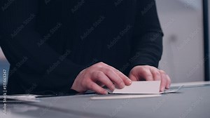An employee in a factory assembles packaging from cut-out paper.