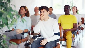 Portrait of attentive positive young student attending training session in lecture class with group of men in college