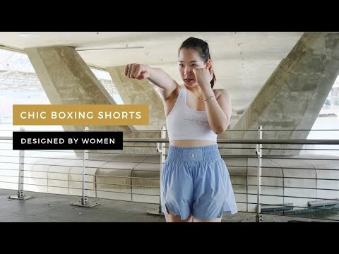 Female boxer shadowboxing in chic baby blue Boxing Shorts with built-in safety shorts