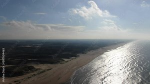 Cinematic 4k aerial video of the Dutch coastal dunes and north sea beach on a sunny day