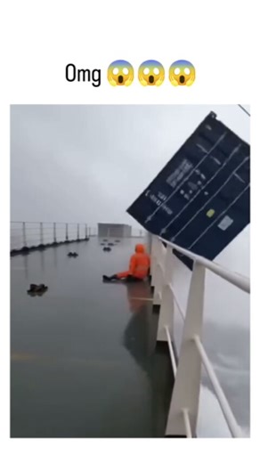 intertan.io on Instagram: "This Instagram viral reel depicts a cargo ship crew member in an orange survival suit narrowly avoiding a blue shipping container sliding overboard in rough seas, amassing over 8.8 million views and sparking widespread shock. Many replies question its realism, citing implausible physics like the man's calm posture amid violent waves, consistent with a January 2026 surge in AI-generated maritime hazard clips on social platforms. Though fabricated, the footage highlights
