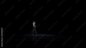 Male ballroom dancer performs solo latin american dance in white shirt,black trousers.Dancing across stage, retreating into darkness,jupming,making steps,chaines tours.High quality Full HD footage