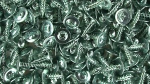 Metallic texture background. Screws and cogs. Tools for fixing and repairing. Background of the bolts. Stainless steel bolts. Galvanized metal fasteners. Close up. The view from the top.