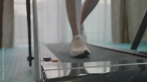 A woman is running on a treadmill. Concept of determination and focus as the woman works out