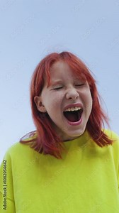 vertical shot. teenager screams loudly and looks at the camera. Upset girl screaming, teenager with facial piercing. shock and emotional breakdown, depression.