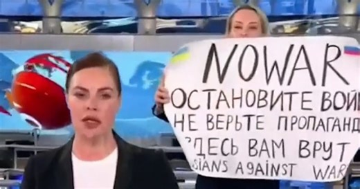 Protester with 'No War' sign walks onto Russian state TV set