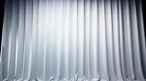 The sheer curtain gently sways in a light breeze, illuminated by soft, bright light, creating a soothing ambiance in the tranquil indoor space.