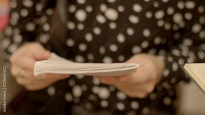 Close-up of hands flipping through the pages of a notebook or a slender book at school. Tactile experience of leafing through written pages, showcasing the engagement and focus on the content within.