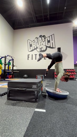 Woman does handstand on balance ball