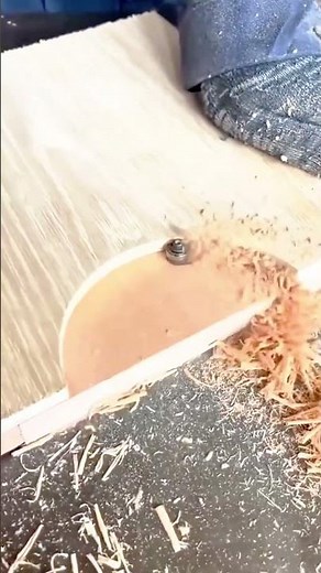 using a router tool to carefully trim and shape the edge of a wooden board during woodworking task