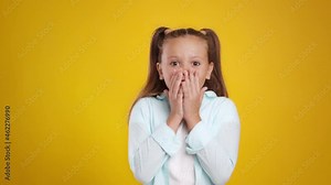 Childhood and fear. Cute little girl feeling afraid and frightened, covering mouth in shock and getting back