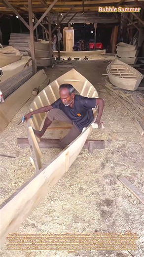 Construction navale artisanale : un artisan façonnant un canoë en bois dans un atelier traditionnel