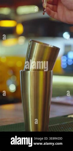 A hand uses a dropper to put liquid ingredients into a shaker at a bar Stock Video Footage - Alamy
