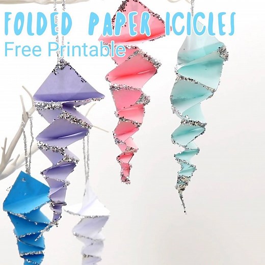 How pretty are these Folded Paper Icicles? They're easy to make with the printable pattern, just print, cut and fold! A lovely Winter craft for hanging on the Christmas tree or for a wintery display. Get the printable pattern here: https://kidscraftroom.com/folded-paper-icicle-craft/ | Kids Craft Room