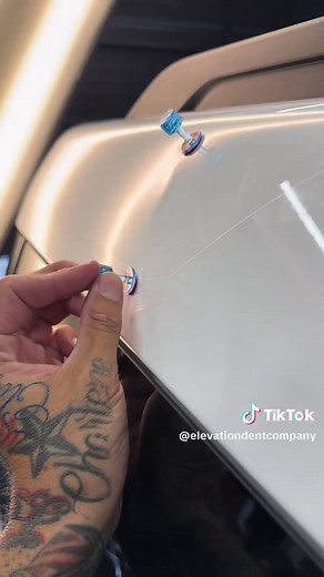 Dent Glue👇🏽 After cleaning the panel with alcohol and hitting it with a torch. I came in with a Keco centipede tap and some Dent Out Glue placing it directly in the center of the Dent. I installed a mini lifter from Cam Auto and started working the metal up from top to bottom. From that point, I did some tap down work with my knockdown and a Anson soft cap. I reduced my tabs down to some smaller ones from Keco to pull out my upper and lower low spots. Once I got the metal reversed, I did my ta