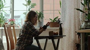 Woman measures blood pressure using blood pressure monitor on her wrist at home