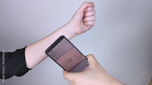 The woman shows his hand with a chip implanted which is read or scanned by a special device. Concept of chipping and implantation of electronic technologies. Cybernetics and the nanofuture. Cyberpunk