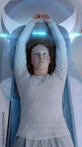 Vertical shot of MRI or CT scan, lies on bed moving inside machine. Visual effects of scanning brain and body of woman. High-tech augmented reality and futuristic equipment in advanced clinic.