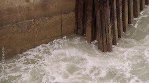 Propeller wash hitting sea wall, as large ferry departs Dover, England