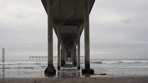 Time Lapse on the beach from under pier - California - Pacific Ocean - Surfers - Clouds