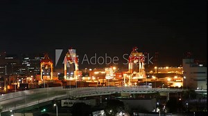 A city skyline at night with a bridge in the middle. The lights on the bridge and the buildings are lit up, creating a warm and inviting atmosphere