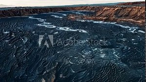 A rocky surface covered in thick crusty layers of cooled lava the textures and patterns resembling a volcanic landscape frozen in time.