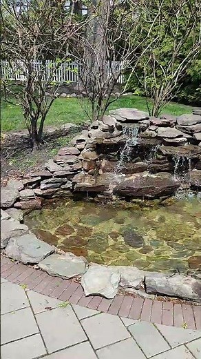 A Waterfall Built Into A Backyard Patio