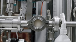 Beer Production-Pouring Malt Grains Into A Large Grinding Tank At The Brewery. Modern beer factory. Beer flow goes through the pipe at the brewery. Equipment in brewery.
