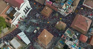 People run in crowds at Indra Jatra Festival at Basantapur Durbar Square, Kathmandu Nepal. Pagoda temples are surrounded by vibrant diverse people, enjoyment, drone shot, 4K