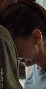 Husband and wife reconcile after a quarrel. They're hugging. The woman is crying. Close-up of her face