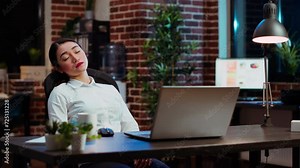 Tired employee asleep on computer desk chair suddenly waking up, struggling to finish writing emails. Drowsy businesswoman working overnight, typing on laptop, trying to stay awake, camera B