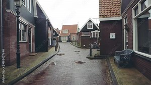 Walk along traditional Dutch town street in Volendam on a rainy day, Netherlands
