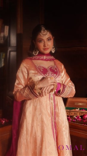 Omal on Instagram: "Introducing Liyara🌸 Shiny peach tissue maysuri frock featuring embroidered silk patchwork on the sweetheart neckline, velvet detailing on embroidered sleeves, and an embroidered net and maysuri double-layered flare finished with gota details to complete the festive look. Dupatta: Contrasting hot pink net dupatta with embroidered border and gota lace finishing. Jewelry @madeforher.pk #fyp #festivewear #pakistanifashion #eidcollection #festive"