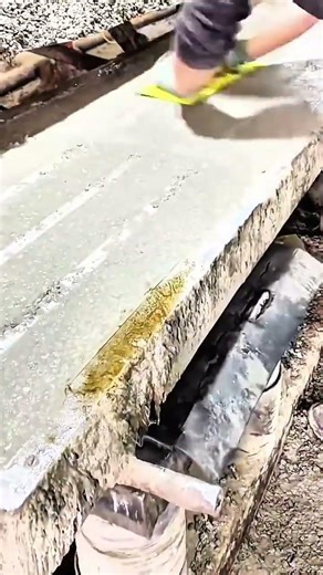 Gloved hand smooths wet concrete float glides surface settles