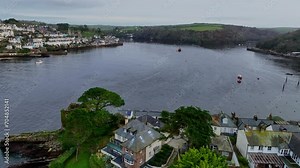 Flying over rooftops and up the river Fowey from Polruan Cornwall South east England