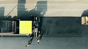 Road construction process. Workers are making a roadway from bitum