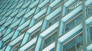 Handheld shot of cool artsy windows of the Public Library in Seattle, Washington USA that create abstract lines and grids with an industrial style of exposed bolts and a blue greenish hue.