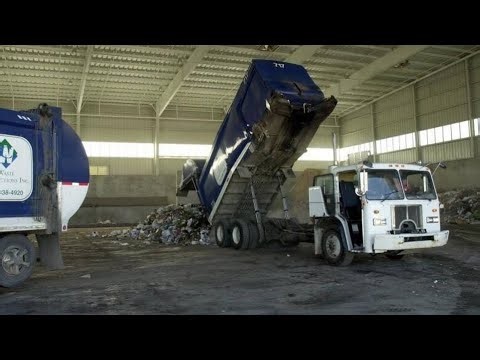 Manual Side Loader Packing Trash in Kansas