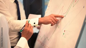 Cropped view of intelligent trade owners cooperating on statistic information using flip chart for making memo notes, two persons collaborating for create economy strategy