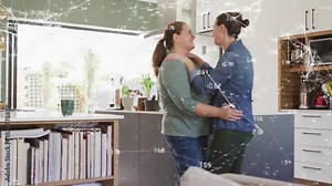 Two women stepping closer and hugging in kitchen, animated network overlay showing connection tech